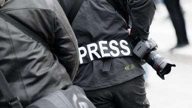 Ein Fotoreporter trägt auf einer Demonstration einen Aufnäher mit dem Text «PRESS» auf seiner Jacke, um sich gegenüber Polizei und Demonstranten als Journalist zu kennzeichnen