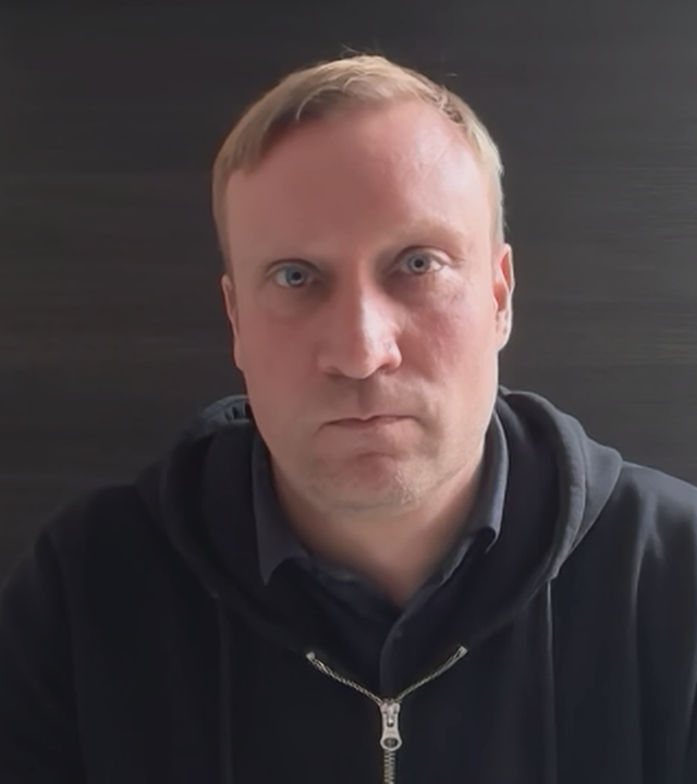 Politikwissenschaftler Benjamin Höhne vor einem grauen Hintergrund.