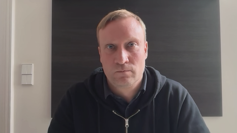 Politikwissenschaftler Benjamin Höhne vor einem grauen Hintergrund.