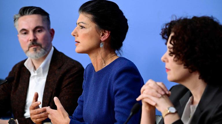 Fabio De Masi, Sahra Wagenknecht und Amira Mohamed Ali vor einem blauen Hintergrund.
