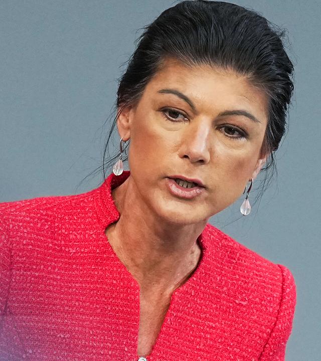 BSW-Vorsitzende Sahra Wagenknecht vor einem graublauen Hintergrund.