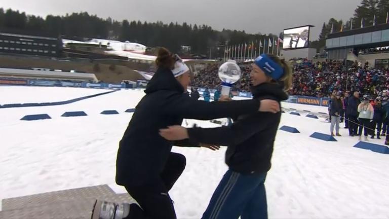 Franziska Preuß überreicht Lou Jeanmonnot beim Weltcupfinale die Kristallkugel für den Gesamtweltcup