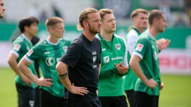 Die Spieler des SC Preußen Münster, angeführt von Jorrit Hendrix, verabschieden sich nach dem 1:1-Unentschieden von den Fans, während der Verein aus der 2. Bundesliga abstieg.