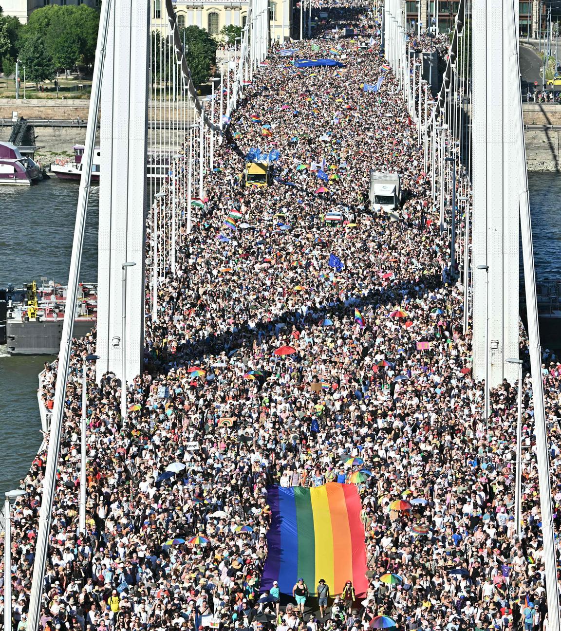 Eine Menschenmenge trägt eine Regenbogenflagge, während sie am 28. Juni 2025 an der Pride-Parade im Stadtzentrum von Budapest teilnehmen.