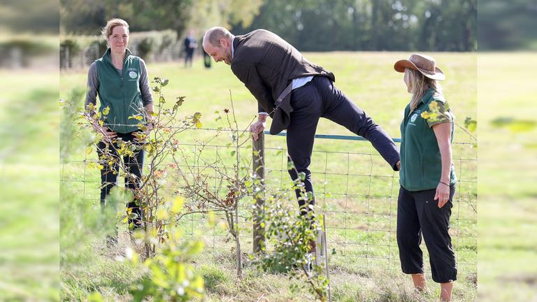 Prinz William klettert über einen Zaun. 