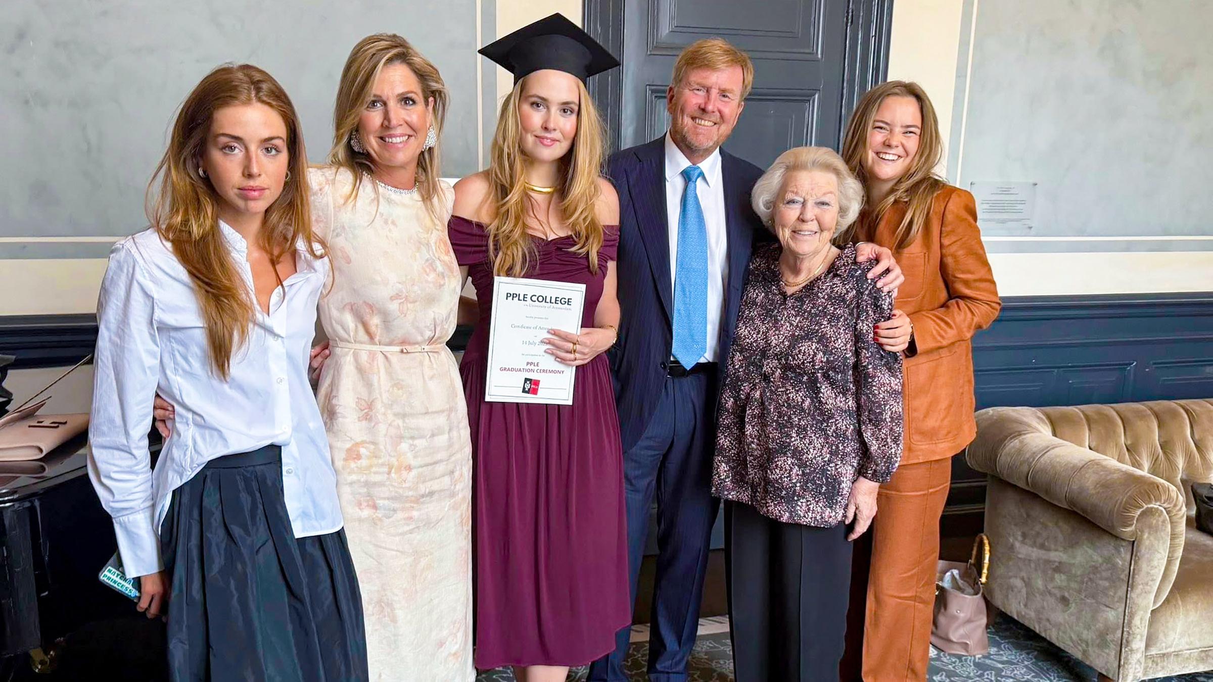 Prinzessin Amalia hält ihr Abschlusszeugnis hoch und ist umgeben von ihrer Familie.