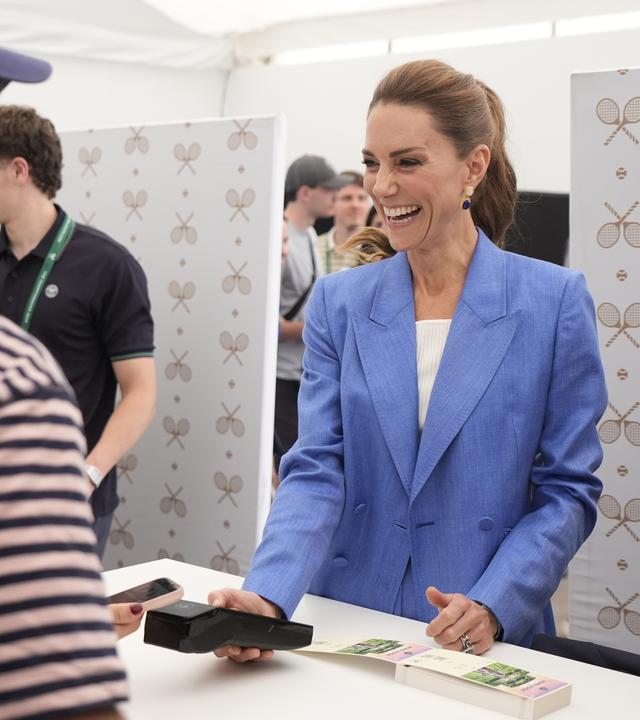 Prinzessin Kate hilft lachend an der Ticketkasse in Wimbledon aus. 