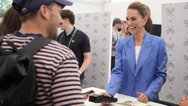 Prinzessin Kate hilft lachend an der Ticketkasse in Wimbledon aus. 
