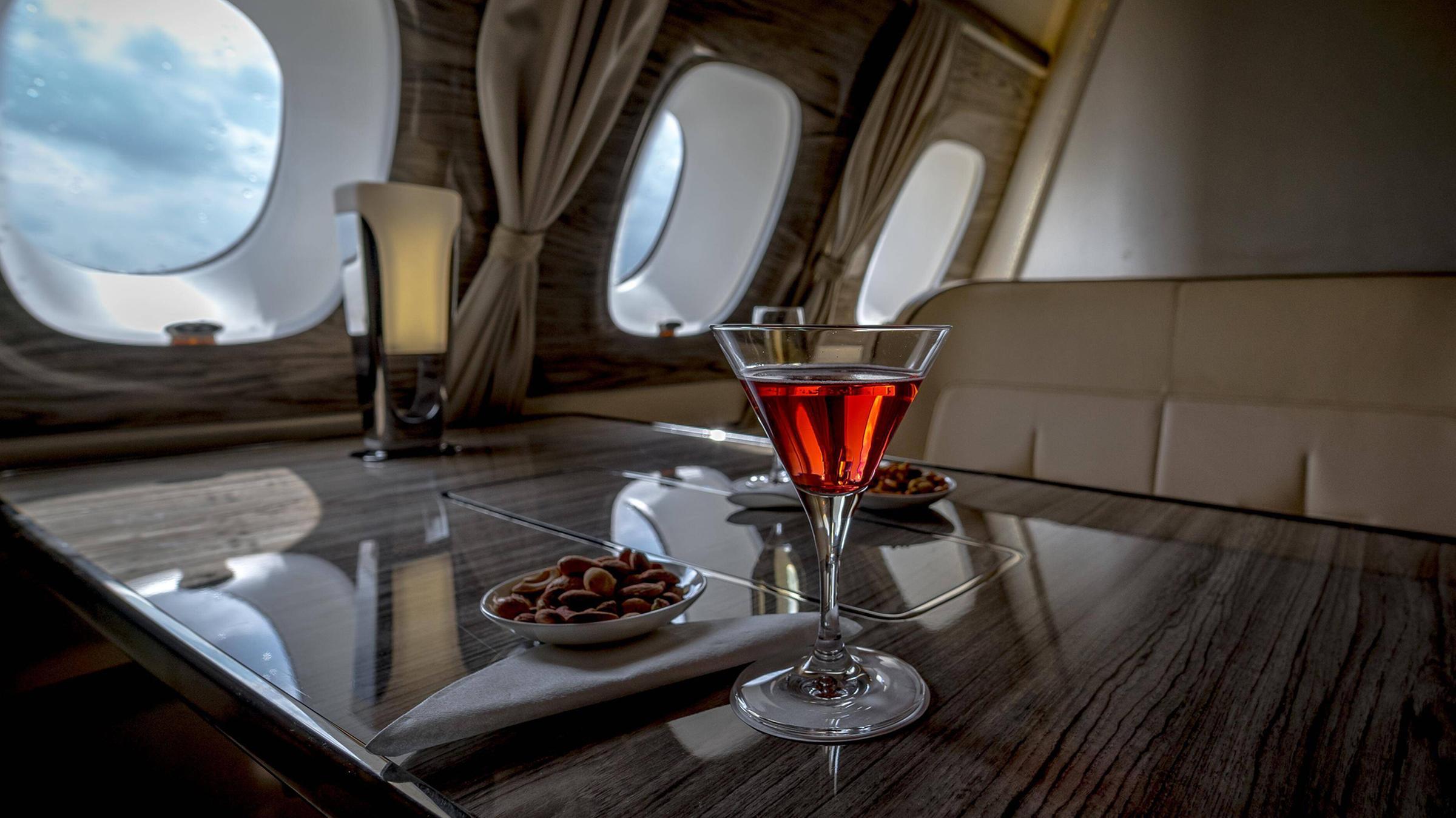 Ein Drink steht in der Kabine eines Privatjets bereit.
