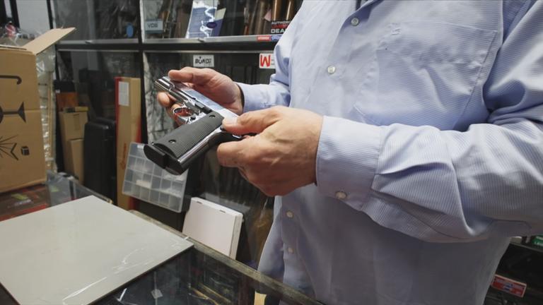 Verkäufer hält Pistole in der Hand