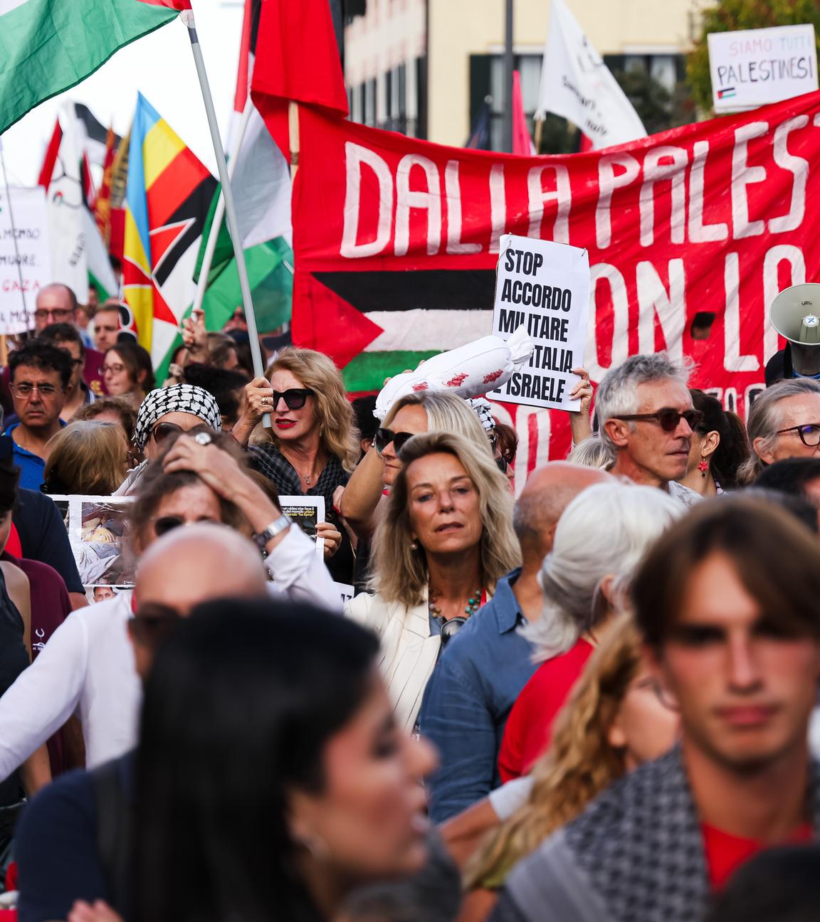 Menschen, die für Frieden in Palästina und Gaza demonstrieren. Sie halten Banner und die Palästina-Flagge hoch. 