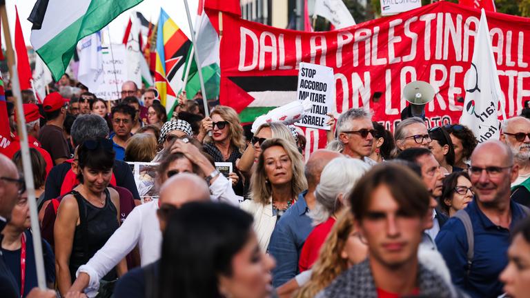 Menschen, die für Frieden in Palästina und Gaza demonstrieren. Sie halten Banner und die Palästina-Flagge hoch. 