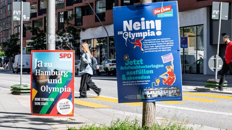 Zwei Plakate werben mit gegensätzlichen Positionen zur Olympia-Bewerbung, darunter "Ja zu Hamburg und Olympia" (SPD) und "Nein! zu Olympia" (Die Linke) am 28.05.2026 in Hamburg.