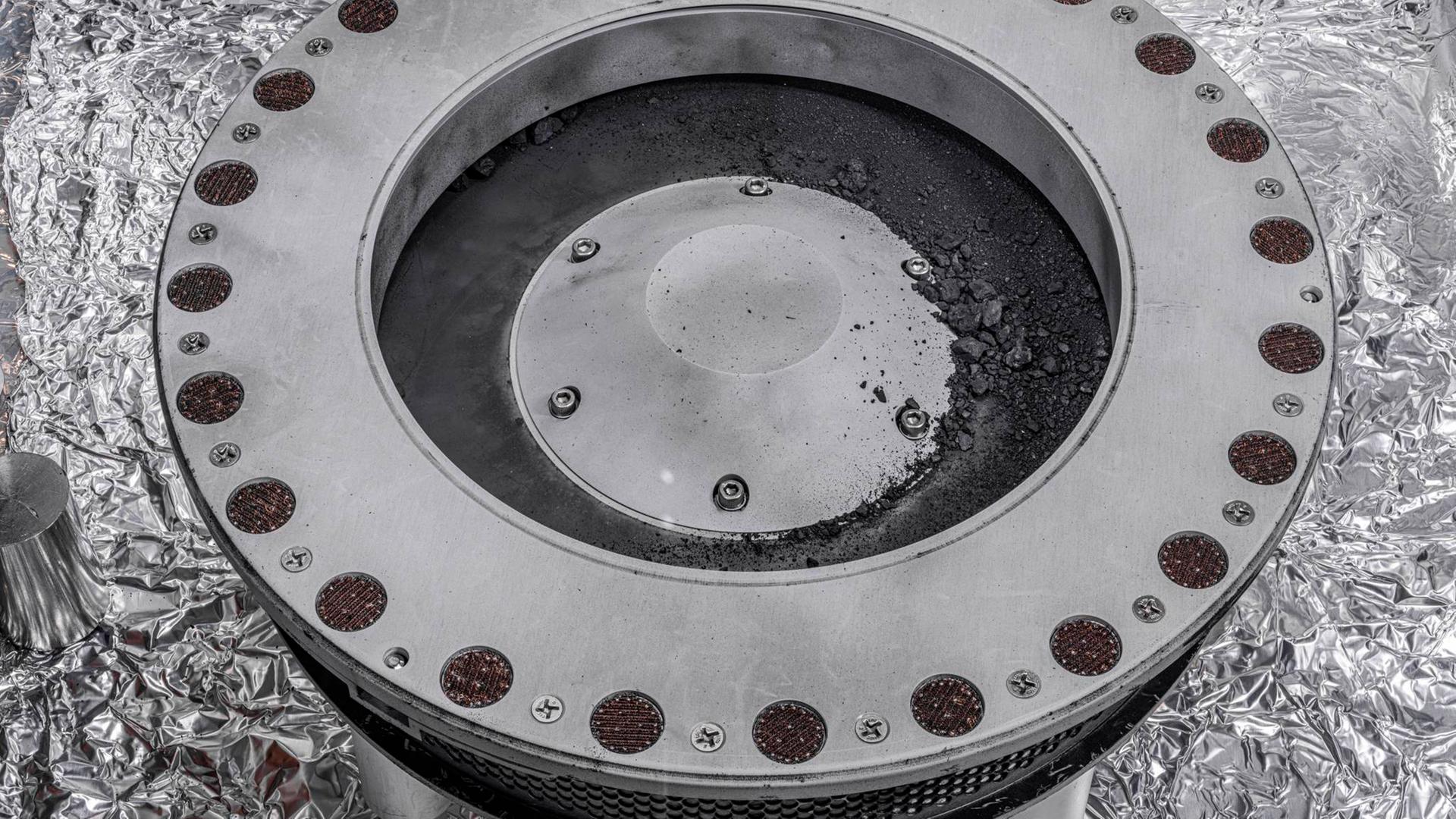 Dieses von der Nasa zur Verfügung gestellte Foto zeigt die Außenseite des Osiris-Rex-Probenbehälters mit Material vom Asteroiden Bennu