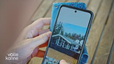 Person schaut sich auf dem Smartphone Ferienwohnungsbilder an