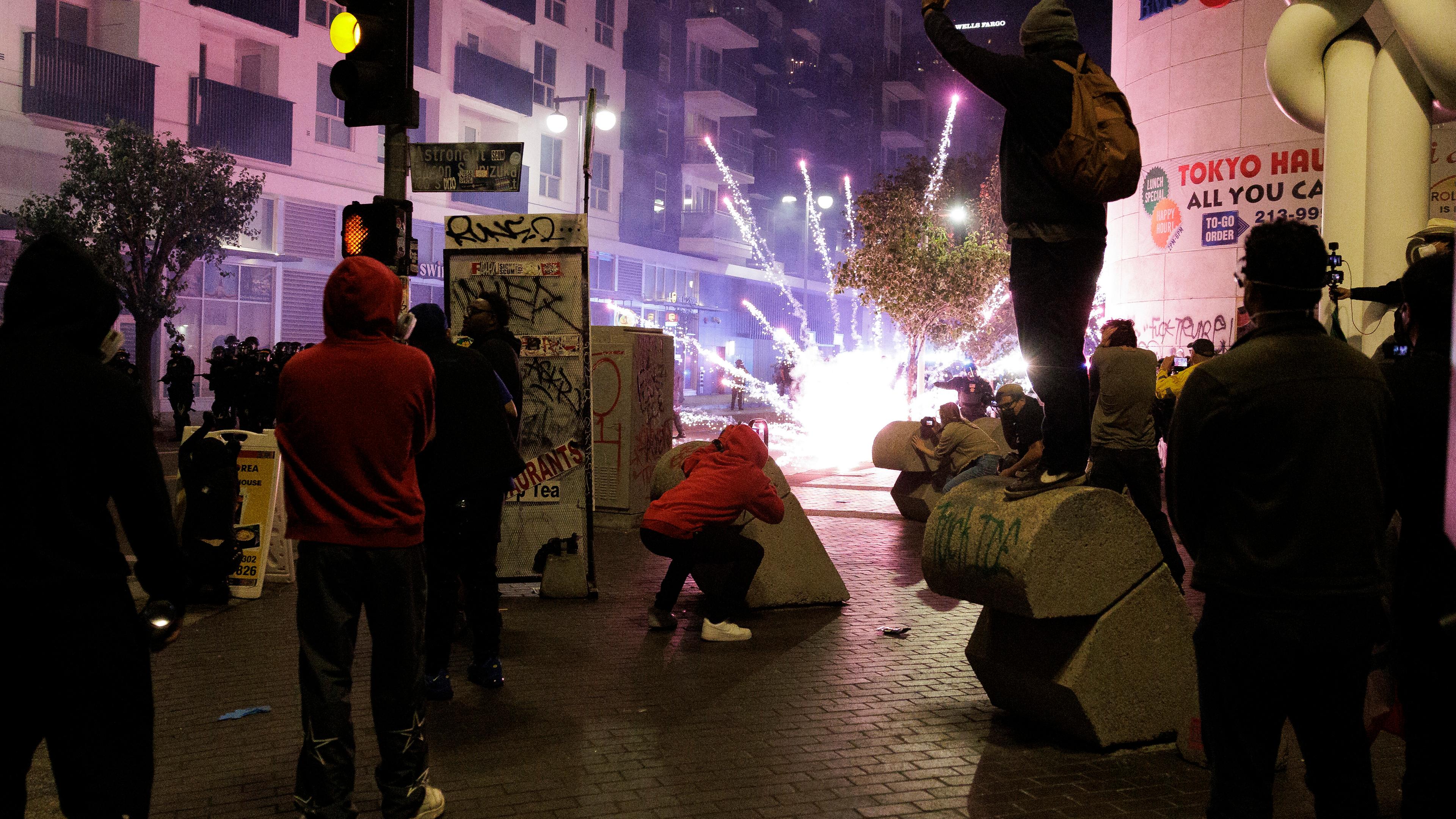 Ein von Demonstranten geworfener Feuerwerkskörper explodiert in der Nähe von Beamten des Los Angeles Police Department.