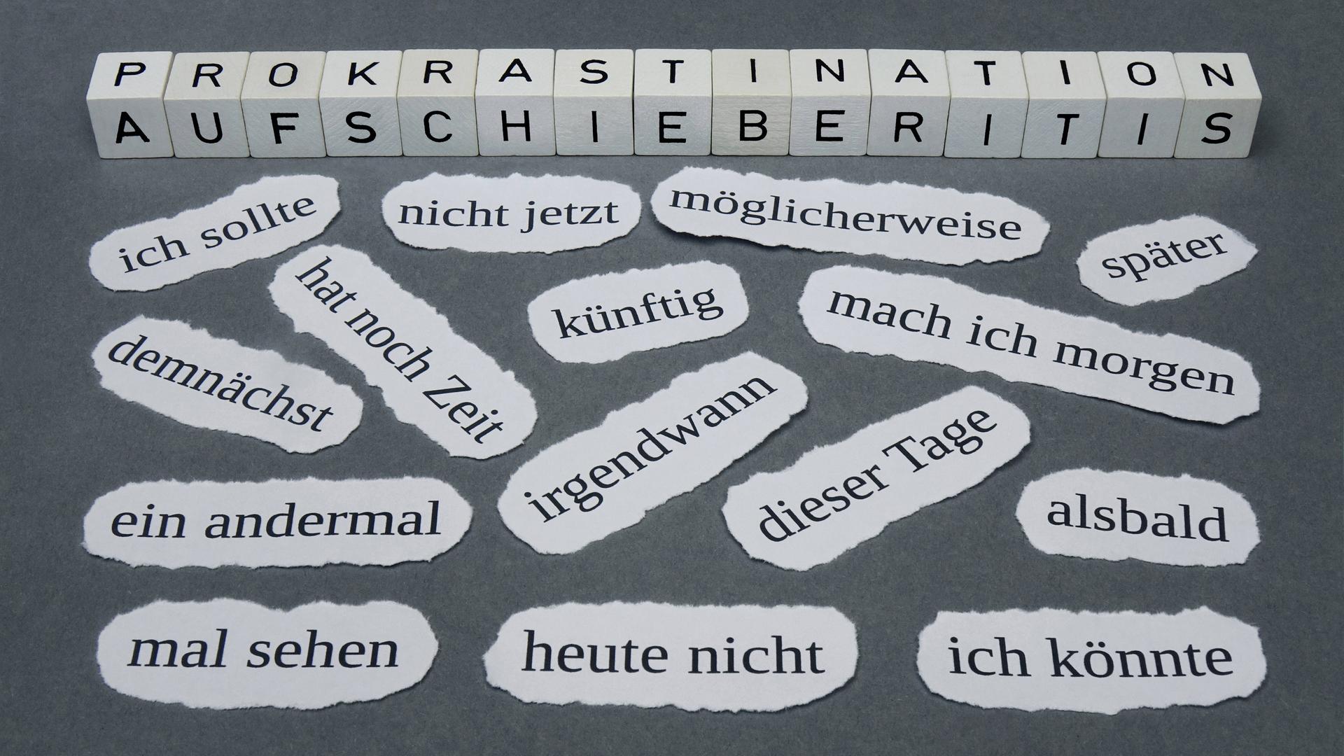 Schlagworte zum Thema Prokrastination liegen auf einem Untergrund.