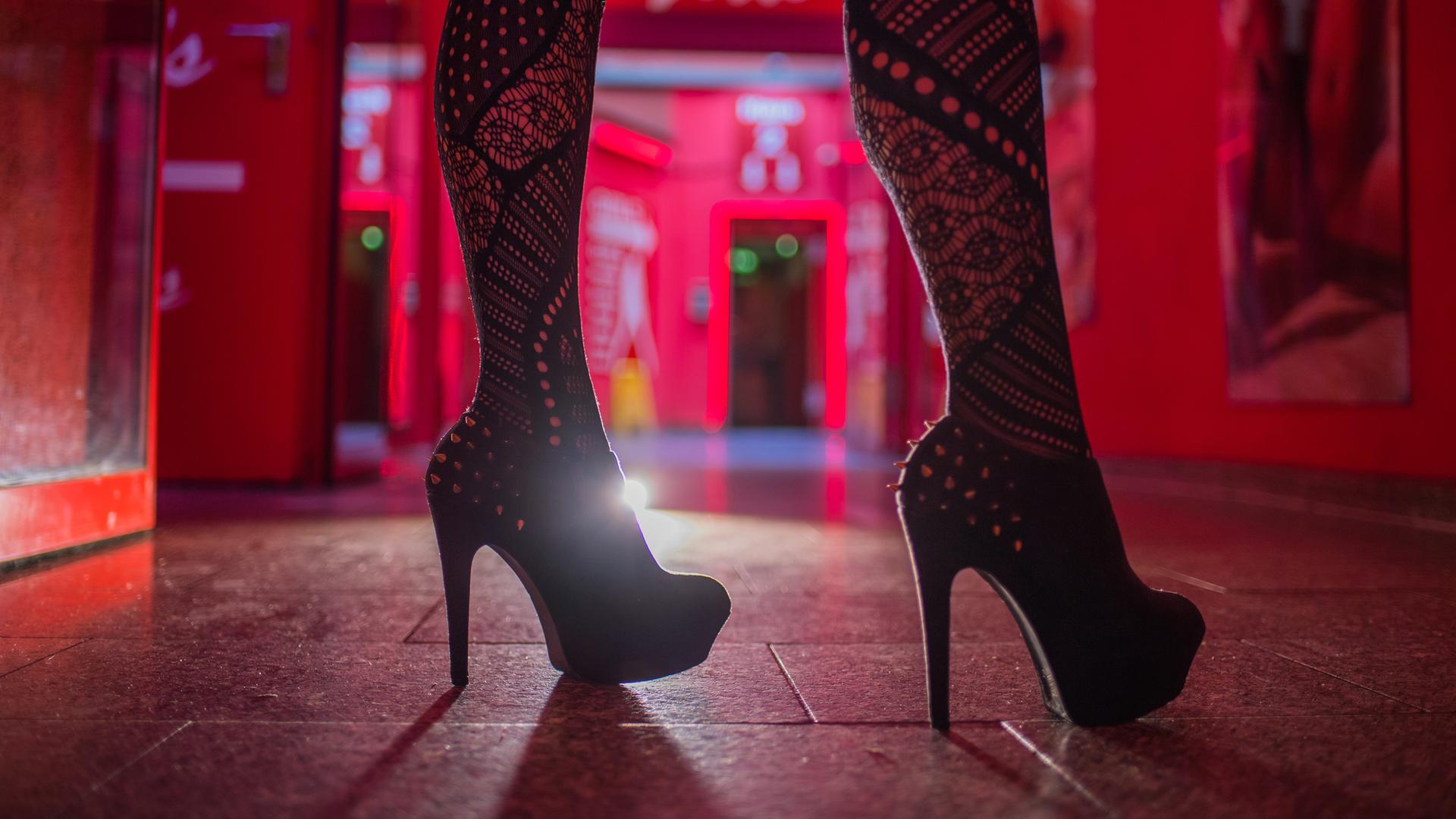 Archiv:  Eine Frau steht im Eingangsbereich einer Animierbar und eines Bordells.