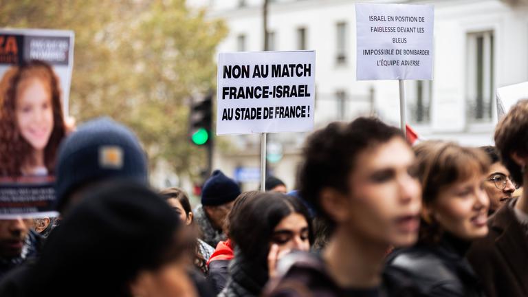 9. November 2024: In Paris wird bei einer propalästinensischen Demonstration ein Schild hochgehalten. Damit wird gegen die Austragung des Länderspiels Frankreich - Israel im Stade de France protestiert