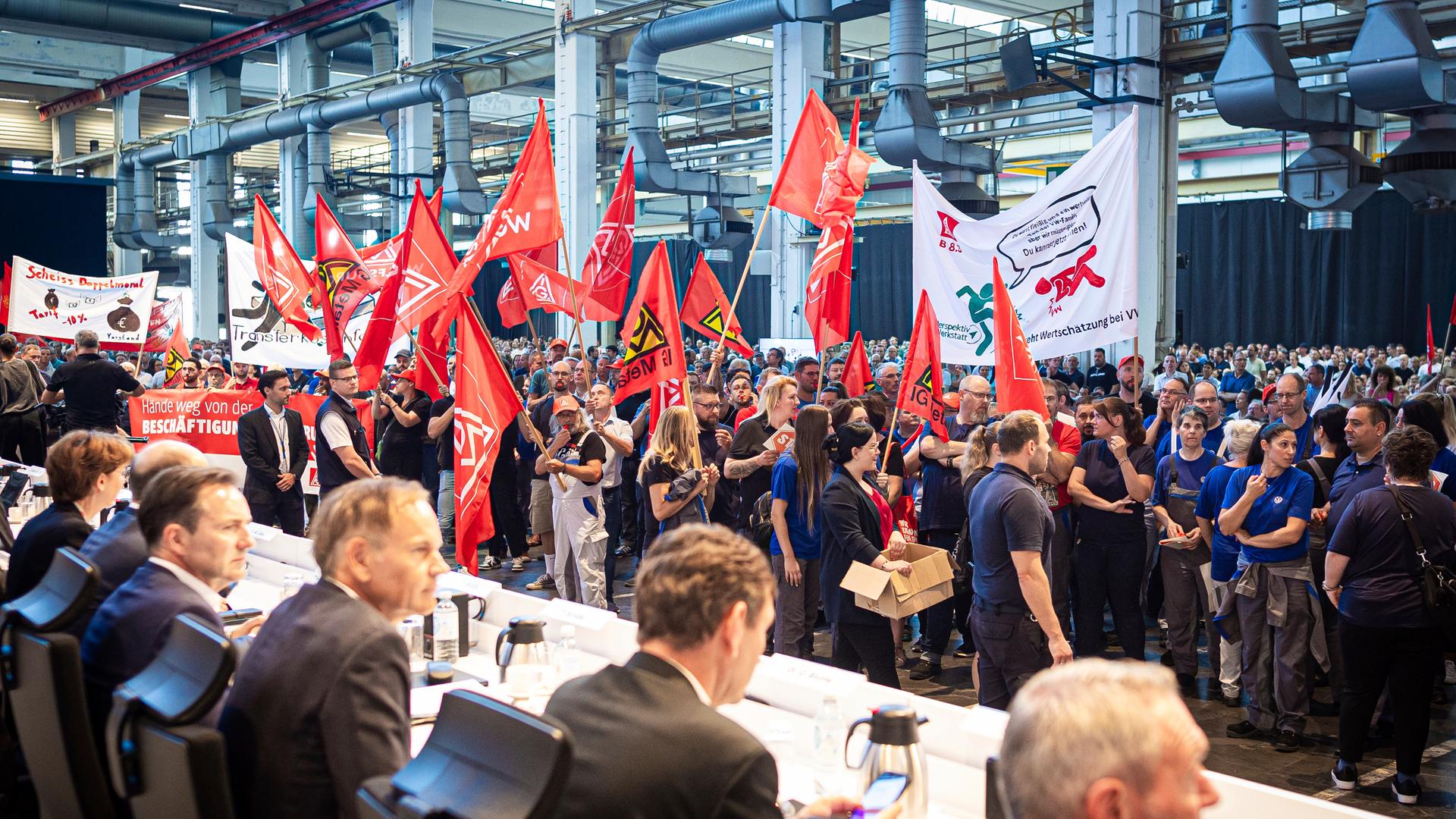 Employees protest before the start of a works meeting in a hall at the VW plant in Wolfsburg, Wednesday, Sept. 4, 2024. Volkswagen has announced that it will tighten its austerity measures due to the tense situation of the core brand. Redundancies and plant closures can no longer be ruled out.
