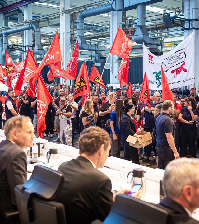 Employees protest before the start of a works meeting in a hall at the VW plant in Wolfsburg, Wednesday, Sept. 4, 2024. Volkswagen has announced that it will tighten its austerity measures due to the tense situation of the core brand. Redundancies and plant closures can no longer be ruled out.