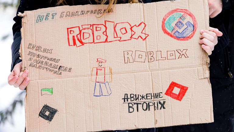 Eine Frau hält bei einer Demonstration ein Schild mit der Aufschrift: "Nein zu Blocks, Roblox ist eine Spiele- und Social-Media-Plattform." Sie protestiert gegen die Sperrung von Roblox in Russland.