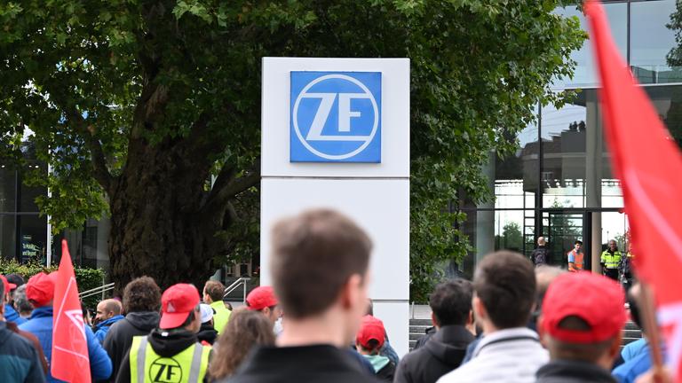 29.07.2025, Baden-Württemberg, Friedrichshafen: Mitarbeiter der ZF Friedrichshafen laufen in einem Demonstrationszug zum Forum des Automobilzulieferer-Konzerns.