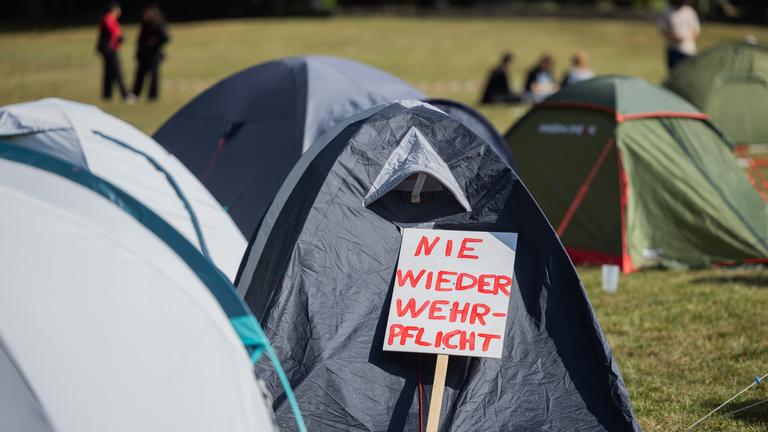 "Nie wieder Wehrpflicht" steht auf einem Schild im Protestcamp des Bündnisses Rheinmetall Entwaffnen.