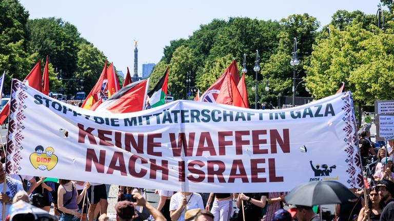 14.06.2025, Berlin: Teilnehmer der Kundgebung der Friedensinitiative "Solidarität mit Palästina! Keine Waffenlieferungen an Israel" demonstrieren mit palästinensischen Fahnen und Bannern für die Solidarität mit den Palästinensischen Gebieten und gegen die Israel-Politik der Bundesregierung.