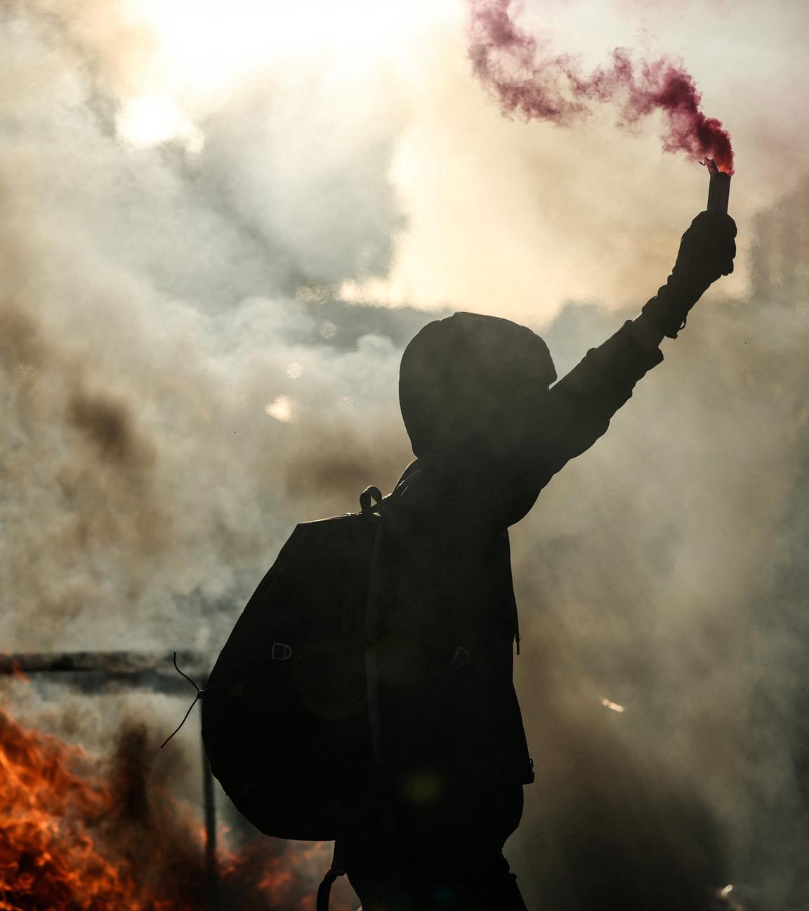 Ein Demonstrant schwenkt eine Rauchflamme neben einer brennenden Barrikade während einer Demonstration der Protestbewegung „Bloquons tout“ („Lasst uns alles blockieren“) im Südosten von Paris am 10. 9. 2025.