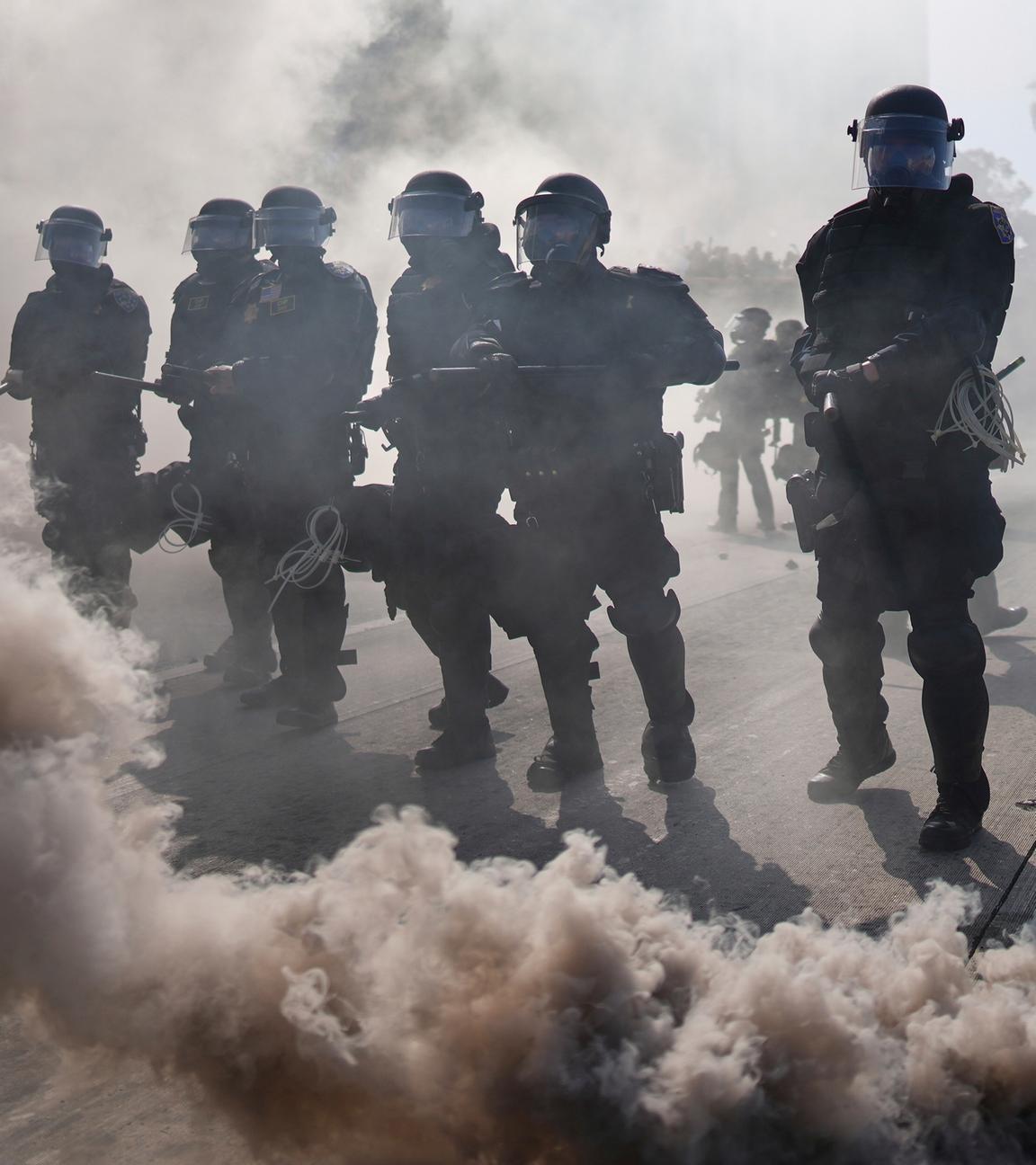 09.06.2025, USA, Los Angeles: Die Polizei ist durch Rauch auf dem 101 Freeway in der Nähe des Metropolitan Detention Center in der Innenstadt von Los Angeles zu sehen.