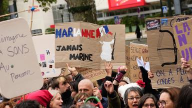 Ein Demonstrant hält während einer Protestaktion am Rande des Parteitags der rechtsextremen Partei «Rassemblement National» (RN) ein Schild mit der Aufschrift «Marianne, niemals Marine»