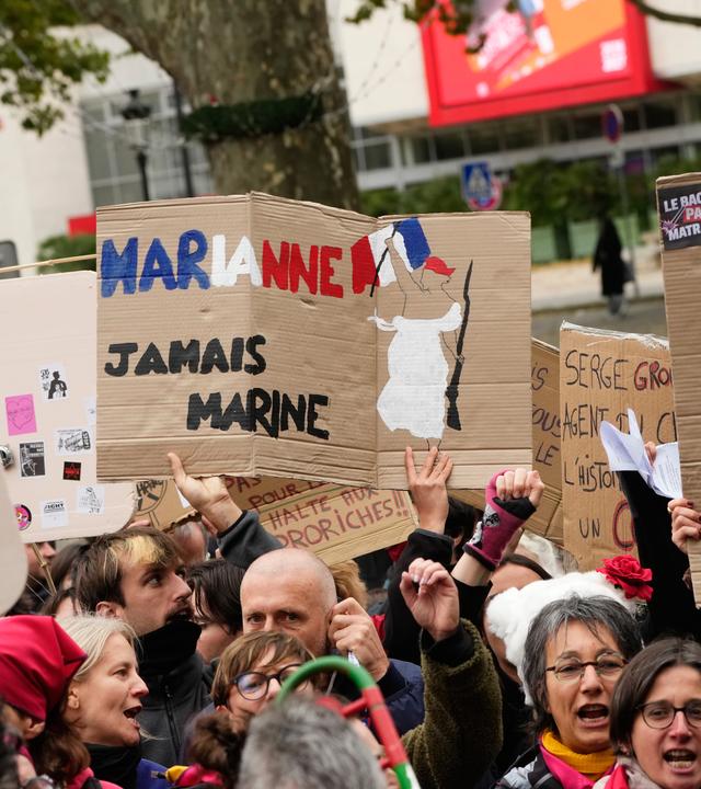 Ein Demonstrant hält während einer Protestaktion am Rande des Parteitags der rechtsextremen Partei «Rassemblement National» (RN) ein Schild mit der Aufschrift «Marianne, niemals Marine»