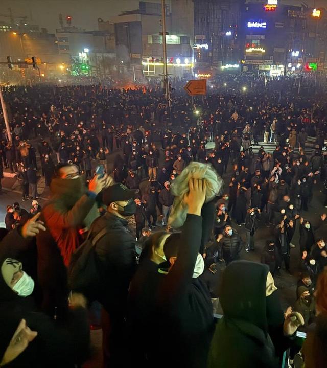 Proteste gegen das Mullah-Regime in Teheran: eine Menschenansammlung auf einem Platz im Dunkeln.