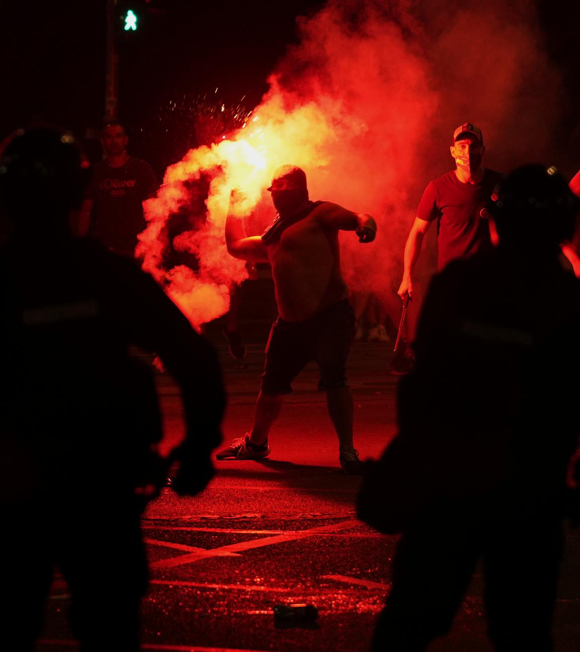 Anhänger des serbischen Präsidenten Vucic werfen während einer Demonstration gegen die Regierung vor dem Büro der serbischen Fortschrittspartei Leuchtraketen auf die Demonstranten. 