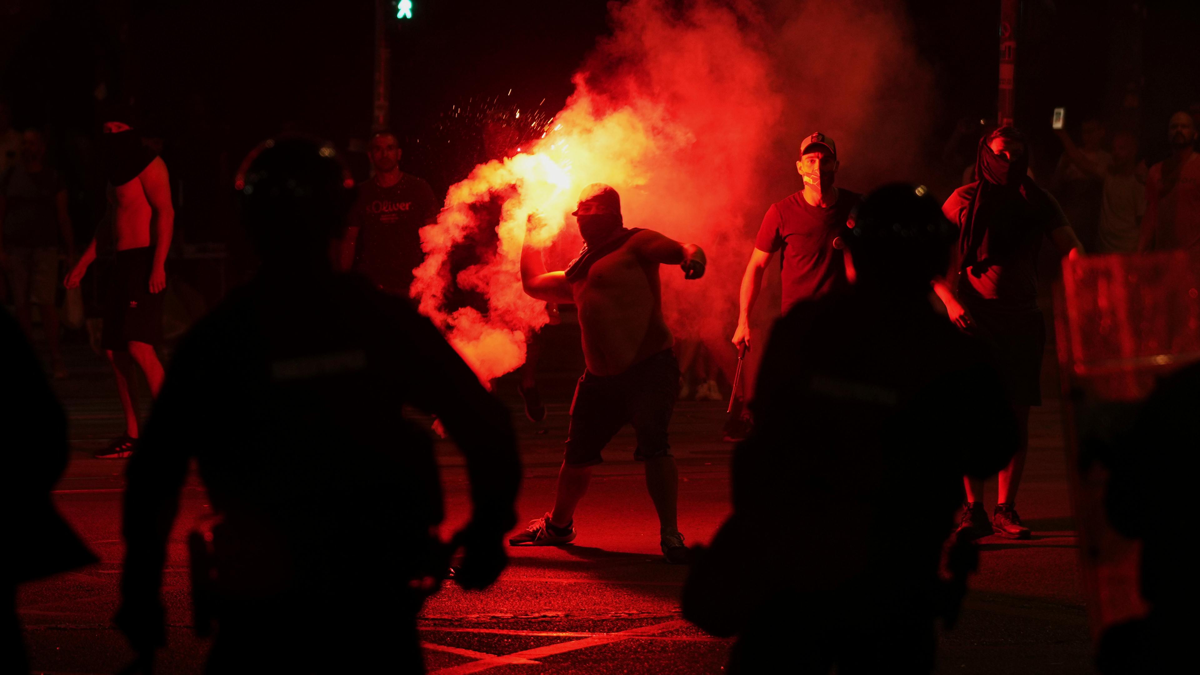 Anhänger des serbischen Präsidenten Vucic werfen während einer Demonstration gegen die Regierung vor dem Büro der serbischen Fortschrittspartei Leuchtraketen auf die Demonstranten. 