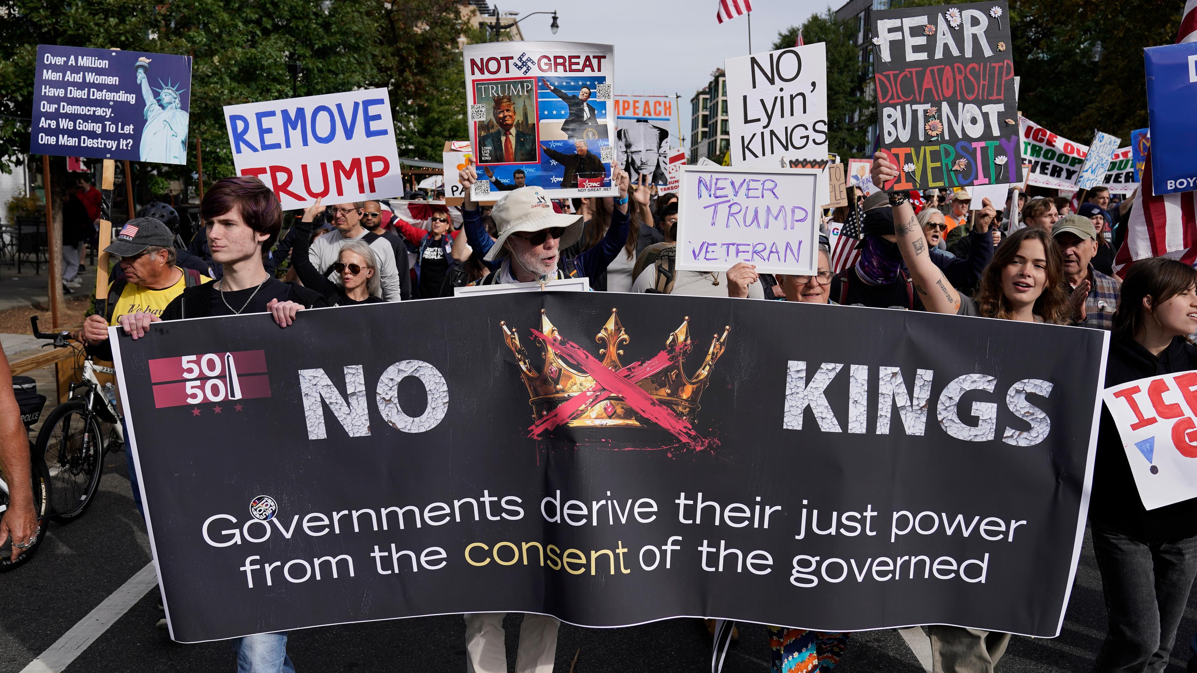 Demonstranten tragen Schilder und Banner, als sie während einer No-Kings-Demonstration zur National Mall marschieren.