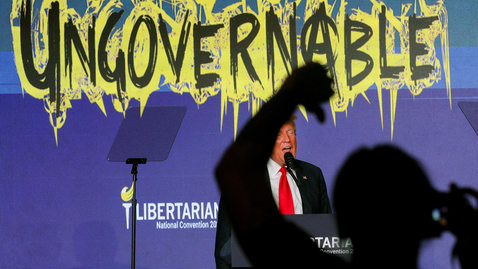 Eine Person in der Menge gestikuliert, während Donald Trump auf dem nationalen Parteitag der Libertarian Party in Washington, USA, spricht.