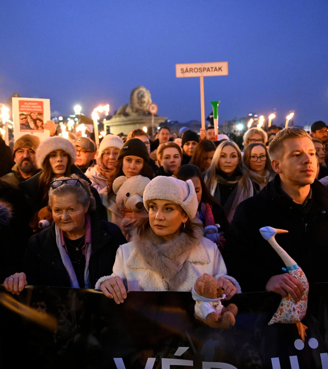 Menschen in Ungarn ziehen mit Schildern und einem Banner durch die Straßen in Budapest, um gegen die Orban-Regierung zu protestieren