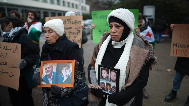 Angehörige protestieren mit Fotos von Opfern des Assad-Regimes