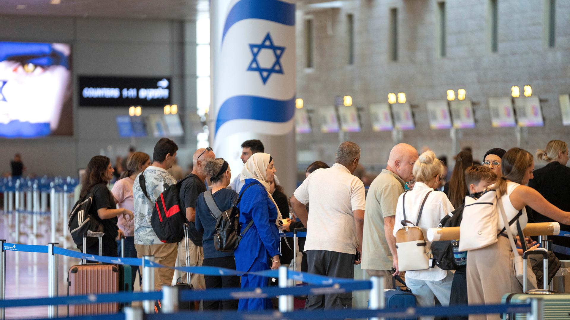 Reisende stehen am internationalen Flughafen Ben Gurion Schlange.