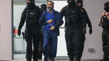  Justizbeamte führen den Angeklagten Taleb al-Abdulmohsen in den Gerichtssaal des temporären Gerichtsgebäudes vom Landgericht Magdeburg. 