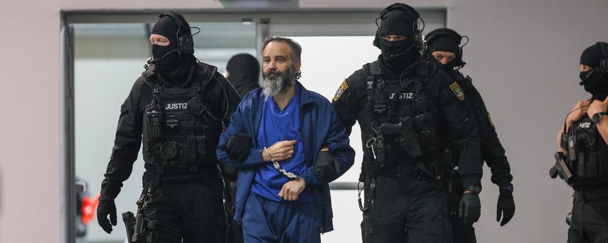  Justizbeamte führen den Angeklagten Taleb al-Abdulmohsen in den Gerichtssaal des temporären Gerichtsgebäudes vom Landgericht Magdeburg. 