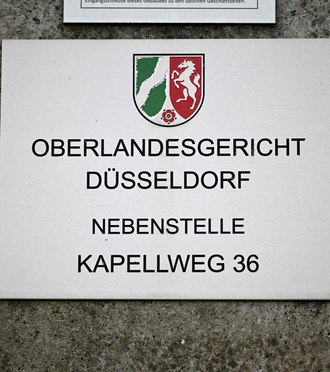 Ein Schild mit der Aufschrift "Oberlandesgericht Düsseldorf; Nebenstelle; Kapellweg 36".