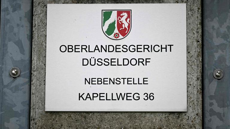 Ein Schild mit der Aufschrift "Oberlandesgericht Düsseldorf; Nebenstelle; Kapellweg 36".