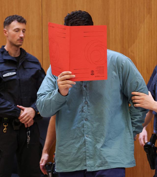 Der Angeklagte Farhad N. steht zu Prozessbeginn im Prozesssaal. 
