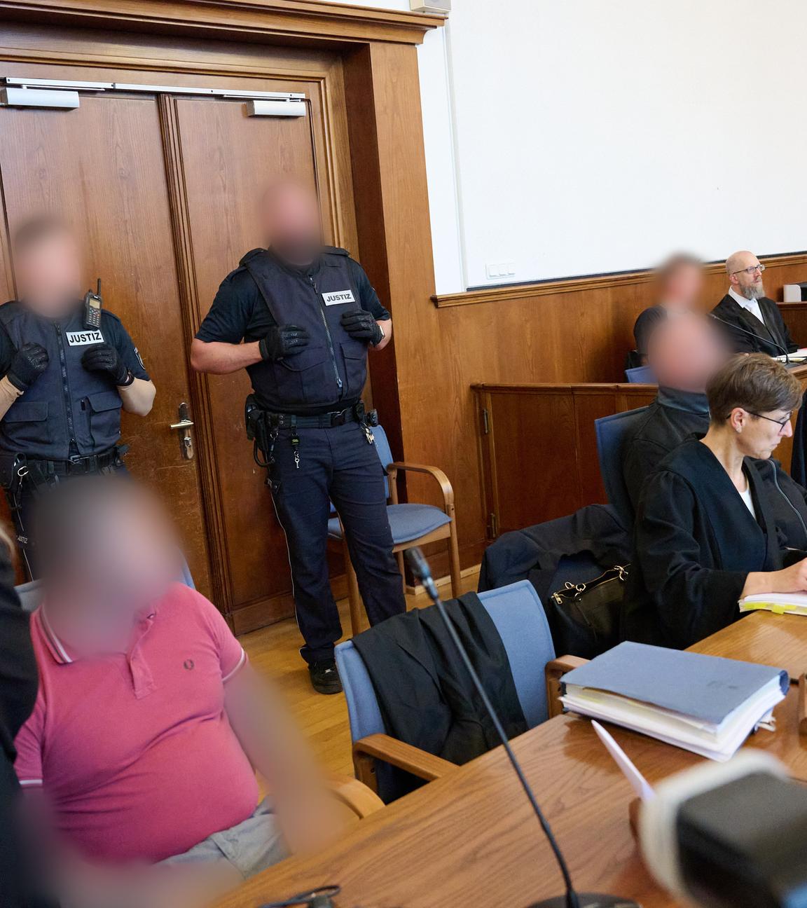 Personen im Gerichtssaal, die Angeklagten sind unkenntlich gemacht
