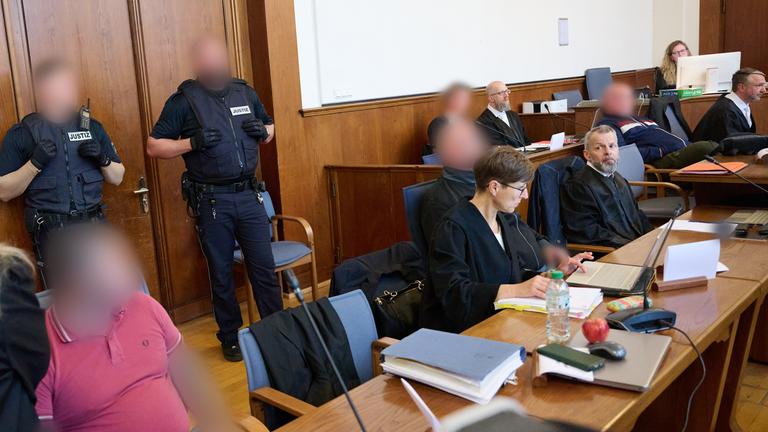 Personen im Gerichtssaal, die Angeklagten sind unkenntlich gemacht