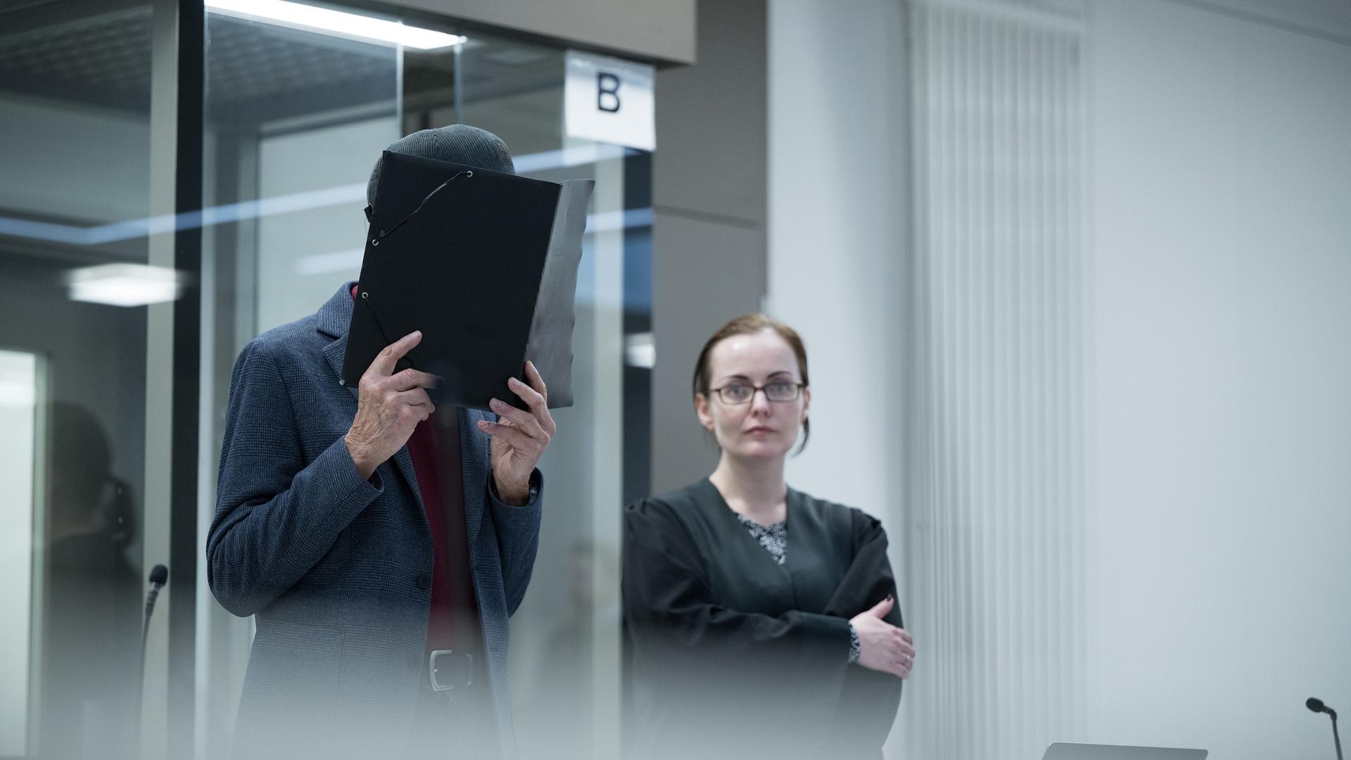 Der Angeklagte hält sich zum Beginn des Prozesses am Kriminalgericht Moabit eine Mappe vor sein Gesicht (Archiv März 2024)