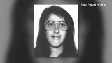 Schwarz-weißes Porträtfoto einer Person mit langen dunklen Haaren und großer runder Brille. Die Person blickt frontal in die Kamera. Das Bild zeigt Kopf und oberen Schulterbereich vor einem hellen Hintergrund. Oben rechts steht der Text „Foto: Polizei Koblenz“.